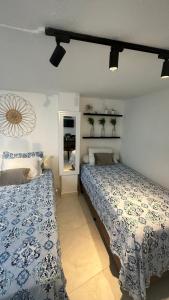 ein Schlafzimmer mit zwei Betten und einem Spiegel in der Unterkunft Kitnet 6 pessoas na Barra in Salvador