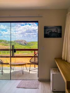 a room with a door open to a balcony with a view at Entre Serras Gastropub e Chalés in Monte das Gameleiras