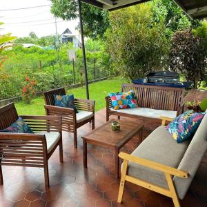 un patio avec des chaises, des tables et un grill dans l'établissement Tahitian villa avec accès mer à Tahiti, à Punaauia
