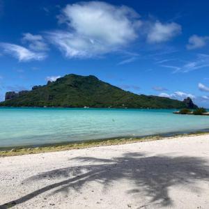 a view of a beach with a mountain in the background at Tahitian villa avec accès mer privé à 300 m in Punaauia