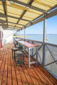 une terrasse en bois avec une table et des chaises sur un bateau dans l'établissement Meningie Waterfront Motel, à Meningie