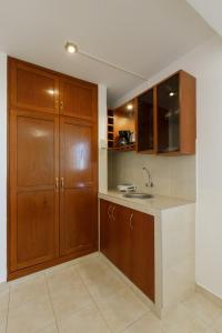a kitchen with wooden cabinets and a sink at Lucky Star Hotel in Chiclayo