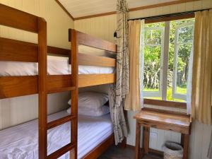 a bunk bed room with two bunk beds and a window at Wisteria Way in Opononi