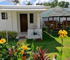 ein kleines weißes Haus mit einem Garten mit Blumen in der Unterkunft Astillo's Guest Houses in Moalboal