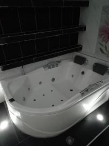 eine weiße Badewanne im Bad mit Beleuchtung in der Unterkunft Hotel Emalú M&C in Quibdó