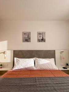 a bedroom with a bed with three pictures on the wall at Caldera Apartment in Caldera