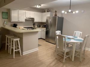 cocina con mesa, sillas y nevera en Sealoft 4 Townhouse, en Myrtle Beach