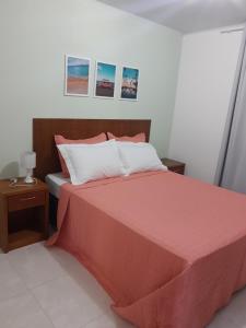 a bedroom with a large red bed with two tables at Casa da Tati in Florianópolis +2 photos