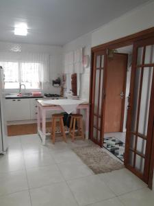 a kitchen with a table and two stools in it at Casa da Tati in Florianópolis