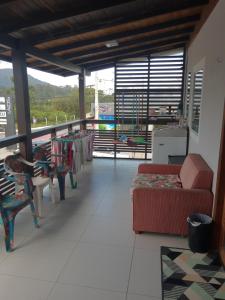 a living room with couches and a table and chairs at Casa da Tati in Florianópolis