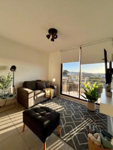 a living room with a couch and a large window at Caldera Apartment in Caldera