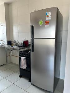 um frigorífico de aço inoxidável numa cozinha com um fogão em Apês Palmeira Dourada - Centro de Palmas e Aromaterapia em Palmas
