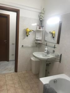 Baño blanco con lavabo y espejo en Casa Iris, en Rozzano