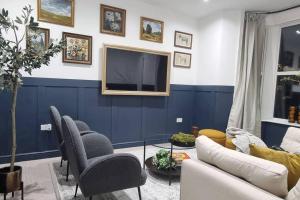ハロゲートにあるLuxury, Interior-Designed, Spacious Homeの青い壁のリビングルーム(テレビ付)