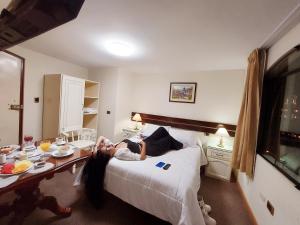 Una mujer acostada en una cama en una habitación de hotel. en Hotel San Francisco INN, en Arequipa 10 fotos más