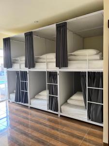 a room with white bunk beds in a room at LoTide Surf Camp Uluwatu in Uluwatu