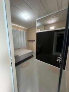 Habitación pequeña con cama y espejo. en Suite 3- Nud Praia bonita Hospedagem en São Francisco do Sul