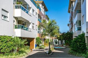 een appartementencomplex met een palmboom ervoor bij MALIBU RESORT CLUB in Florianópolis