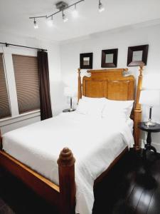 Un dormitorio con una cama con sábanas blancas y dos lámparas. en Charming and comfortable!, en Medford 1 foto más