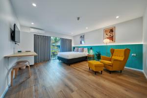 a bedroom with a bed and a yellow chair at Red Star Palm Beach in Gold Coast