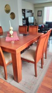 a wooden dining room table with chairs and a table at Familia Segovia Tejada in Quito