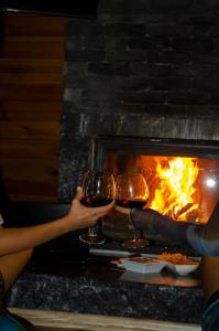 two people holding wine glasses in front of a fireplace at Sapancaimrozveposeidon in Sakarya