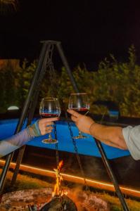 two people holding wine glasses in front of a fire at Sapancaimrozveposeidon in Sakarya
