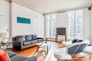 sala de estar con sofá y mesa en Chic Parisian Flat, en París