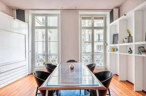 comedor con mesa de cristal y sillas en Chic Parisian Flat, en París