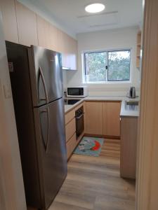 uma cozinha com um frigorífico de aço inoxidável e uma janela em Batemans Bay 2-bedroom gem newly renovated em Batemans Bay