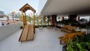 マセイオにあるConforto e tranquilidade, 2 quartos na Pajuçaraの建物の上にベンチとガゼボがあるパティオ