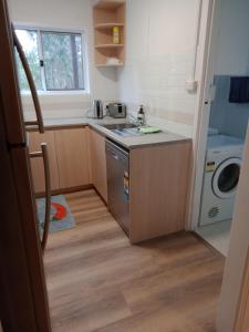 uma pequena cozinha com um lavatório e uma máquina de lavar louça em Batemans Bay 2-bedroom gem newly renovated em Batemans Bay