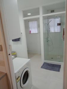 uma casa de banho com uma máquina de lavar roupa e um chuveiro em Batemans Bay 2-bedroom gem newly renovated em Batemans Bay