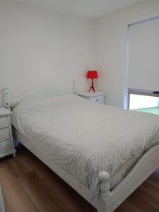 uma cama branca num quarto com uma janela em Batemans Bay 2-bedroom gem newly renovated em Batemans Bay