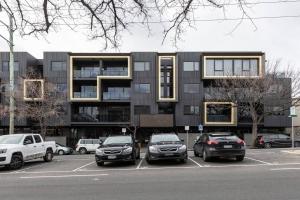 un estacionamiento con autos estacionados frente a un edificio en City-edge Living in Trendy North Melbourne en Melbourne