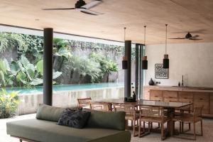een woonkamer met een tafel en een eetkamer bij Sandhouse Berawa in Canggu