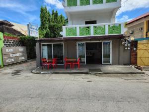 un edificio con sillas rojas y una mesa frente a él en Beach Road Apartments en Matabungkay