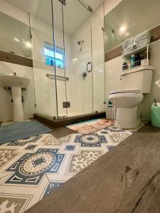 uma casa de banho com um WC e uma cabina de duche em vidro. em Nice 2 Twin bedroom - Best central location in Miami - We have Drop off Service and Laundry for free!!!! em Miami