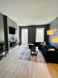 - un salon avec un canapé noir et du parquet dans l'établissement Spacious Apartment Downtown Albany, NY, à Albany