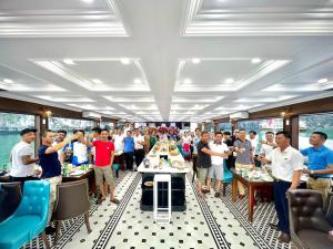 een groep mensen die rond een tafel op een boot staan bij New Way Hotel in Cat Ba +59 foto's