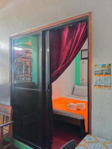 um pequeno quarto com um beliche e uma cortina vermelha em ABBA homestay em General Luna