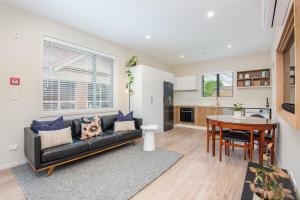 uma sala de estar com um sofá preto e uma mesa em George Little em Dunedin