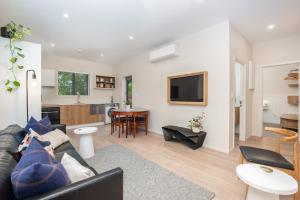 uma sala de estar com um sofá e uma cozinha em George Little em Dunedin