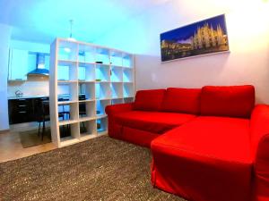 uma sala de estar com um sofá vermelho e uma secretária em L' appartamento sul Naviglio em Milão