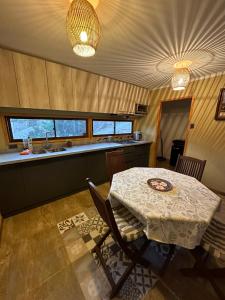a dining room with a table and a kitchen at Cabaña, quincho, piscina y hermosas estrellas La Serena Algarrobito in La Serena