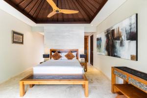 a bedroom with a bed and a ceiling fan at Kejora Beachfront Estate Sanur - Luxurious Villa Seven Kejora in Sanur +12 photos