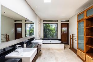 a bathroom with two sinks and a bath tub at Kejora Beachfront Estate Sanur - Luxurious Villa Seven Kejora in Sanur
