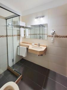 a bathroom with a sink and a mirror at Hotel Genoves in Piriápolis