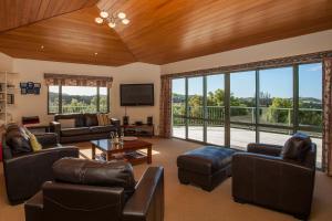 a living room with leather furniture and a large window at Tutukaka Dive Lodge in Tutukaka