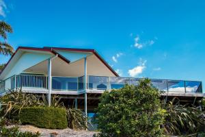 a house with a balcony on the beach at Tutukaka Dive Lodge in Tutukaka